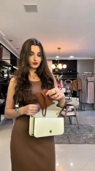 Bolsa branca apresentada em loja de roupas